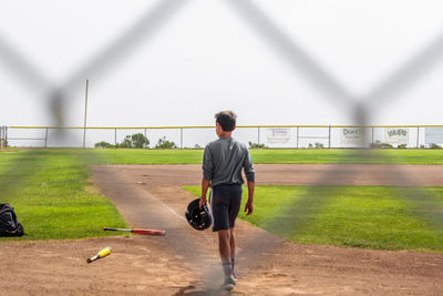 Rear view of man walking on field