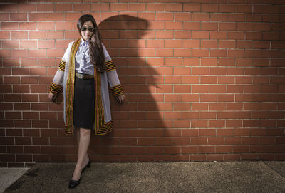 Woman standing against brick wall