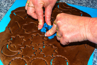 Cropped hands of woman using pastry cutter