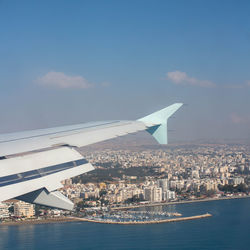 Aerial view of buildings by sea against sky