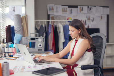 Woman using mobile phone while sitting on table