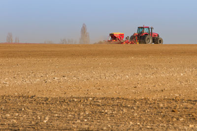 Agriculture field and tractor sowing seeds and cultivating field