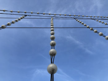 Low angle view of cables against blue sky