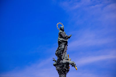 Low angle view of statue against blue sky