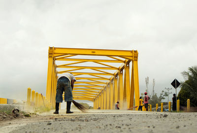 Rear view of people on yellow land against sky
