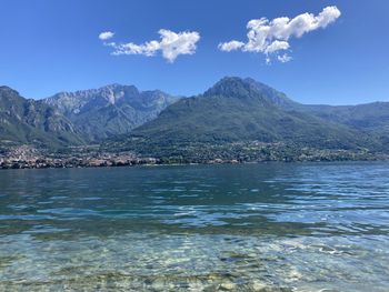 Scenic view of sea and mountains against blue sky