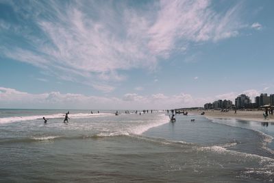 People on beach against sky