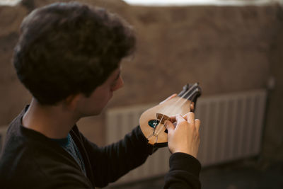 Side view of man using mobile phone while sitting at home