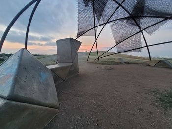 Close-up of abandoned ship on beach against sky during sunset