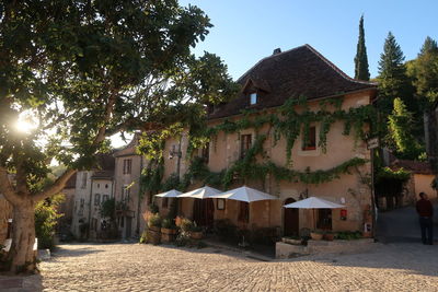 Houses amidst trees and buildings against sky