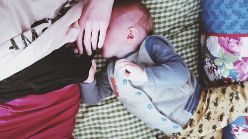 High angle view of cute baby sleeping on bed at home