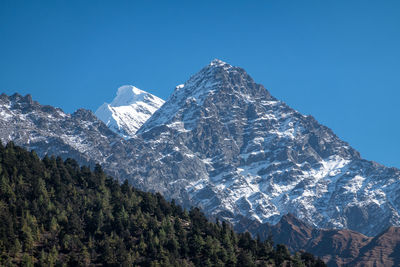 Scenic view of snowcapped mountains against clear blue sky