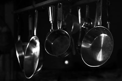 Close-up of kitchen utensils hanging in dark kitchen