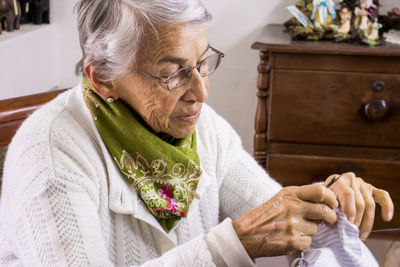 Senior woman sewing mask at home