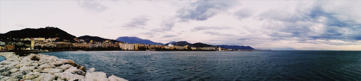 Panoramic view of sea and buildings against sky