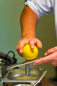 Cropped hands of man grating lemon