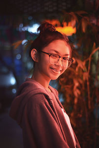 Portrait of smiling young woman standing outdoors