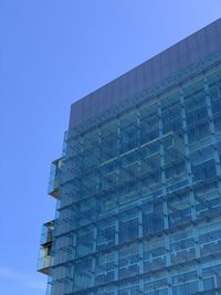Low angle view of modern building against clear blue sky