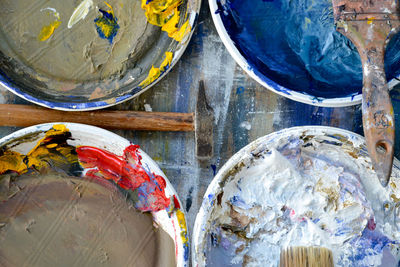Directly above messy paintbrushes by paint on table