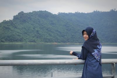 Portrait of woman standing by lake