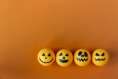 Directly above shot of jack o lantern balls on orange background