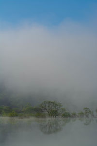 Scenic view of lake against sky during foggy weather