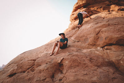 Low angle view of man standing on rock