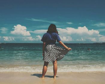 Rear view of woman standing on beach