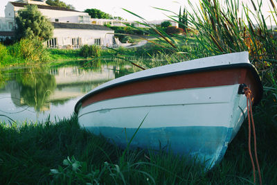 Boat moored on shore by lake