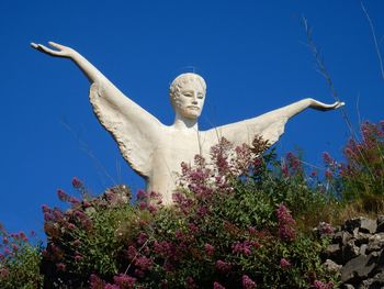 Low angle view of statue against blue sky