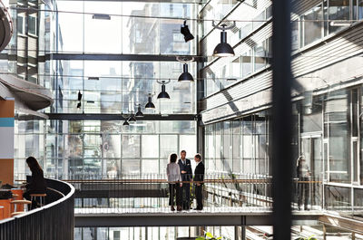 Business colleagues discussing at atrium in office