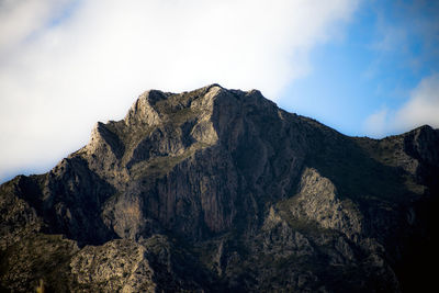 Low angle view of rocky mountains against sky