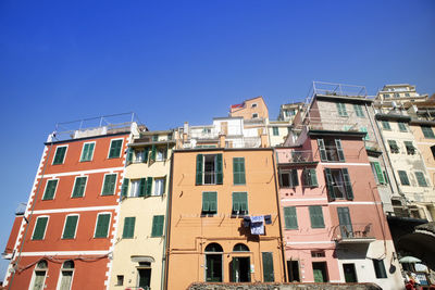 Low angle view of buildings against clear blue sky