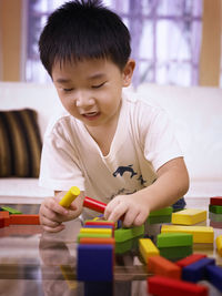Boy playing with colorful toys at home