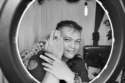 Black and white photo of a smiling young man looking at the camera