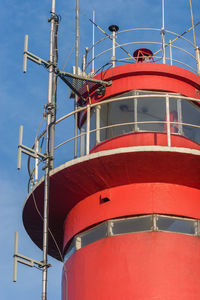 Low angle view of red lighthouse against sky