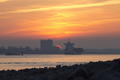 Scenic view of sea against orange sky