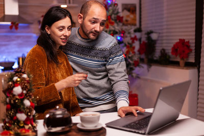 Portrait of smiling woman using laptop at home