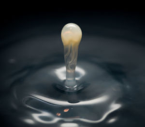 Close-up of drop falling on water