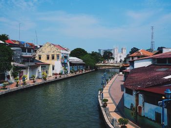 River amidst buildings in city against sky