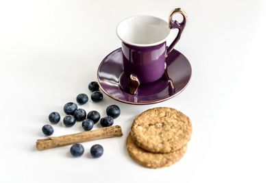 High angle view of coffee cup and cookies against white background