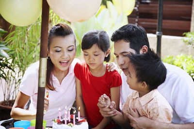 Family celebrating birthday in lawn