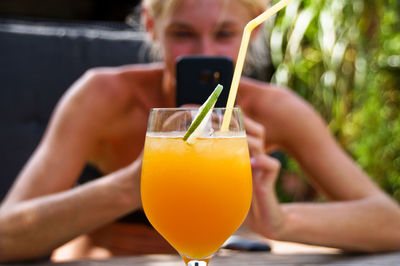 Woman photographing drink on table