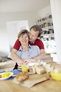 Mature couple embracing during breakfast