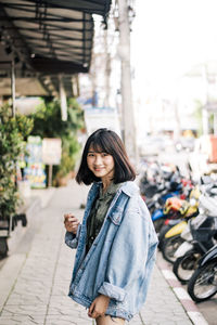 Portrait of woman standing on street in city