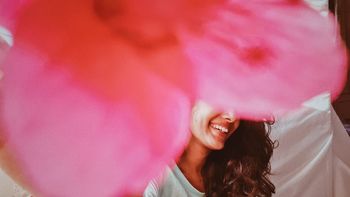 PORTRAIT OF SMILING YOUNG WOMAN WITH PINK HAIR