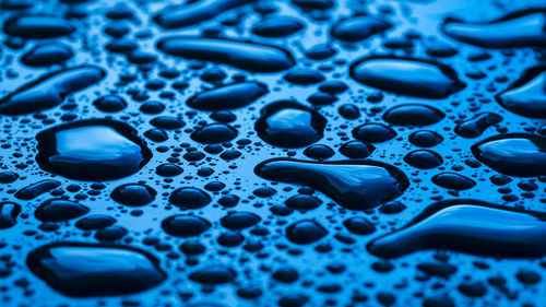 Close-up of water drops on blue surface