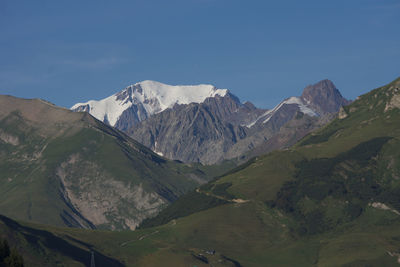 Scenic view of snowcapped mountains against blue sky