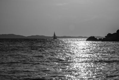 Sailboat sailing in sea against clear sky