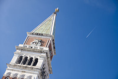 Low angle view of bell tower against blue sky